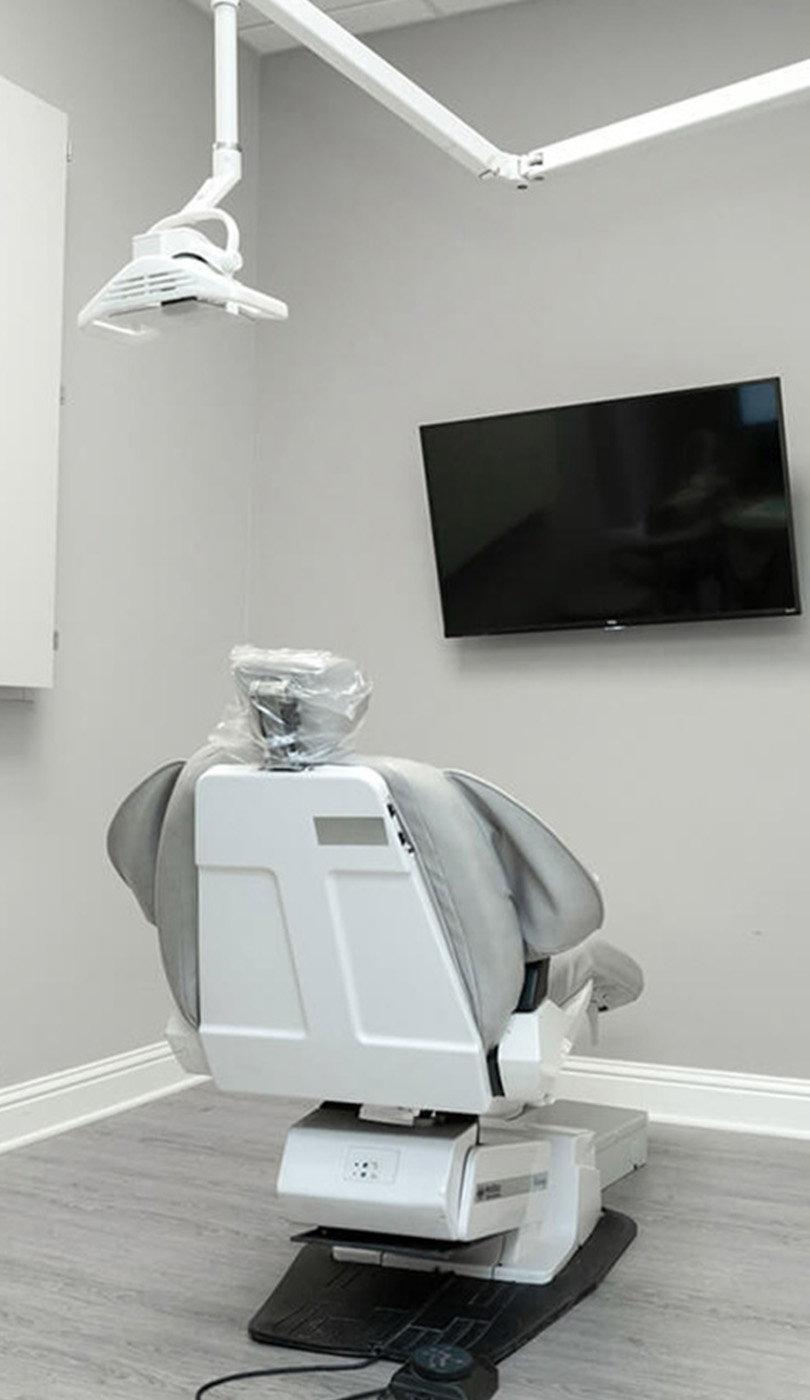 The image shows a modern dental or medical office interior with a dental chair, equipment, and a clean, professional environment.